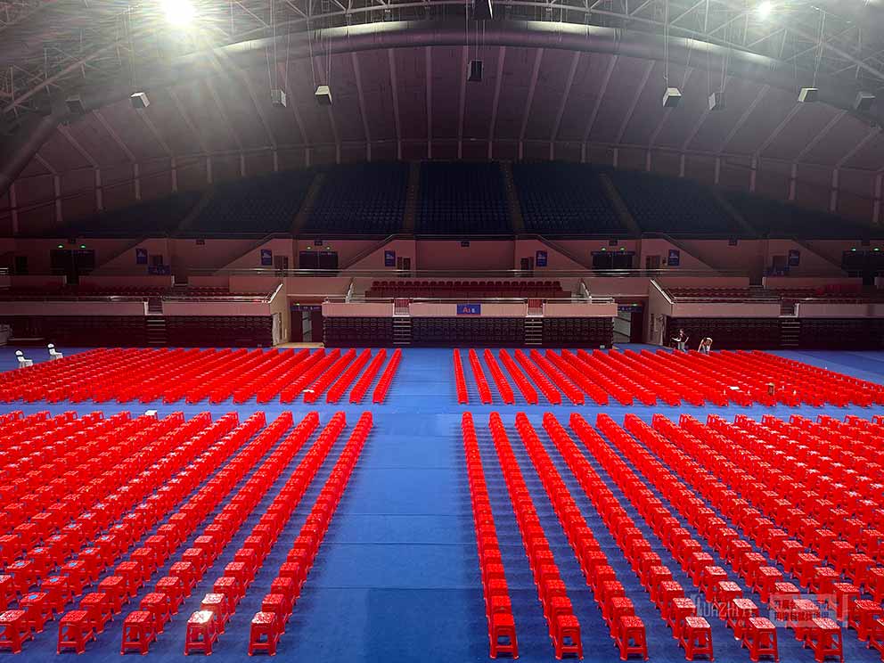 鄭州桌椅出租廠家布置臨時會場現(xiàn)場，紅色塑料凳整齊劃一